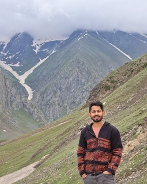 Young man standing against mountainous landform
