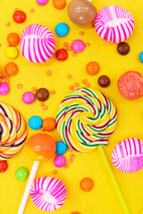 different kinds of Colorful candies isolated on yellow background