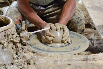 hands of a potter, creating an earthen jar