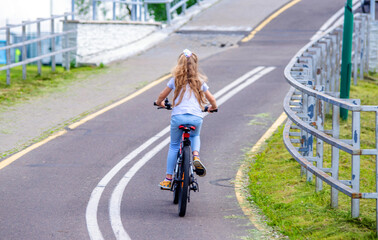 Girl ride on the bike path in the city Park
