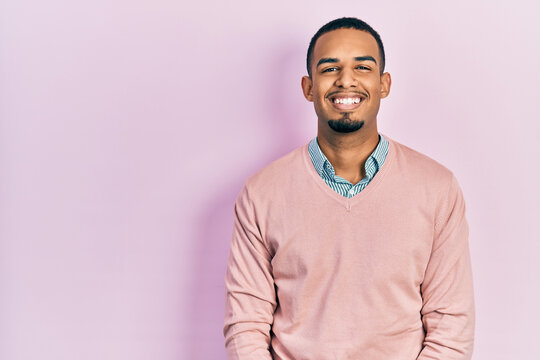 Young african american man wearing elegant clothes looking positive and happy standing and smiling with a confident smile showing teeth