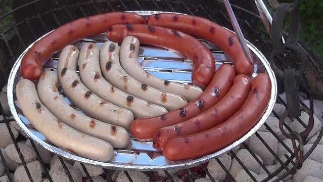 Tasty German white and red bratwurst sausages on the grill