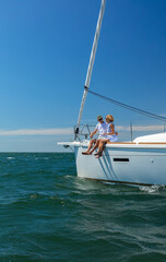 Naklejka premium Senior couple enjoying retirement sailing yacht across ocean