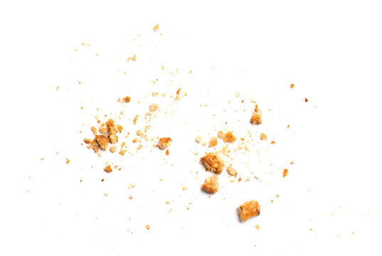 Scattered crumbs of vanilla chip butter cookies isolated on white background. Close-up view of brown crackers. Macro shot of yellow biscuit cake leftovers for your design