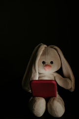 Toy bunny as symbol of child with smartphone. Addiction concept