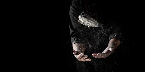 Foto op Canvas Beautiful and strong men's hands knead the dough from which they will then make bread, pasta or pizza. A cloud of flour flies around like dust. Food concept © Надія Коваль