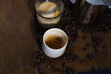 Coffee cup espresso shot and dirty coffee put on wooden table with spread coffee bean.
