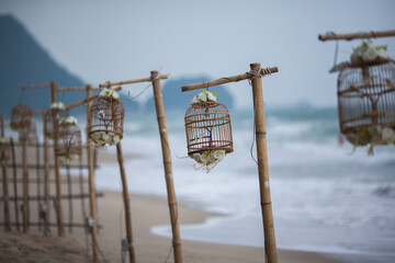 Cage with flower wooden wedding pole on the beach