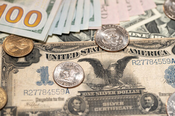 Half Dollar and Eisenhower Dollar coins on historic Dollar banknote.