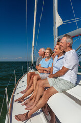 Senior friends enjoying luxury lifestyle relaxing on yacht