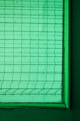 close up of part of glass green insert in green door, architectural geometry, green texture