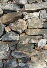 A section of a stone wall featuring randomly stacked stones.