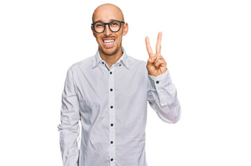 Bald man with beard wearing business shirt and glasses showing and pointing up with fingers number two while smiling confident and happy.