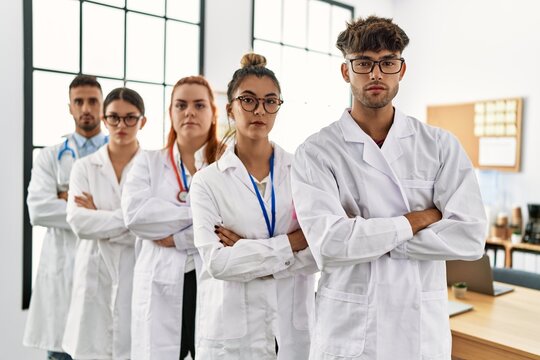 Group Of Young Doctor With Serious Expression Standing With Arms Crossed Gesture At The Clinic Office.