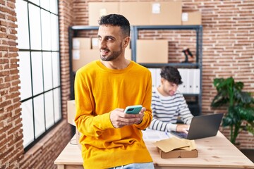 Two man ecommerce business workers using smartphone and laptop working at office