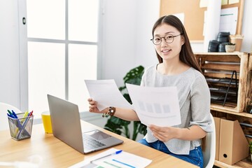 Young asian woman working looking at documents at the office