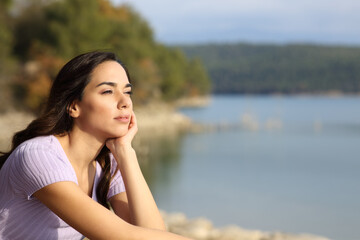 Relaxed woman contemplating lake views on vacation
