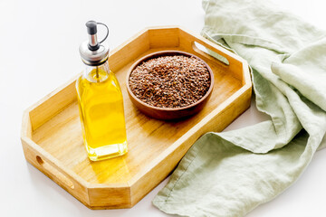 Bottle of sesame cooking oil with seeds in bowl