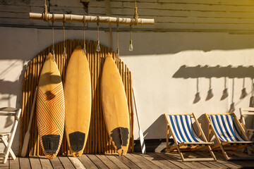 Wooden vintage Surfboard and Bamboo fence stands in the sand.