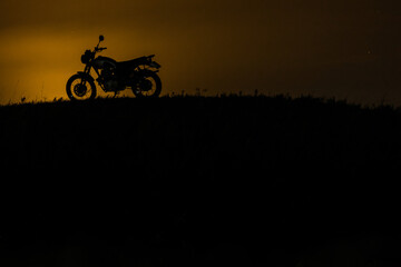 silhouette of a classic motorcycle at night in the moonlight in nature