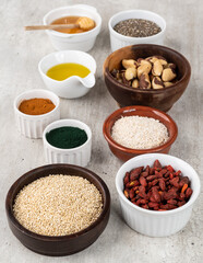 Assorted superfoods in over wooden background. Chia, quinoa, oat, linseed, honey, spirulina and others