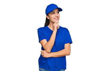Young hispanic girl wearing delivery courier uniform with hand on chin thinking about question, pensive expression. smiling with thoughtful face. doubt concept.