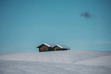 snow covered wooden cabins in the mountains