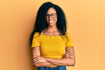 Middle age african american woman wearing casual clothes and glasses winking looking at the camera...