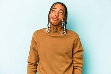Young African American man isolated on blue background dreaming of achieving goals and purposes
