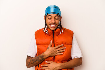 Young African American man isolated on white background laughs happily and has fun keeping hands on...