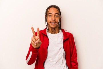 Young African American man isolated on white background showing victory sign and smiling broadly.