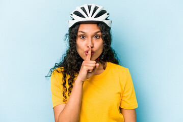 Young hispanic woman wearing a helmet bike isolated on blue background keeping a secret or asking for silence.