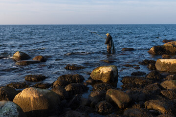 Fototapeta na wymiar Angler in Wathose an der Ostsee