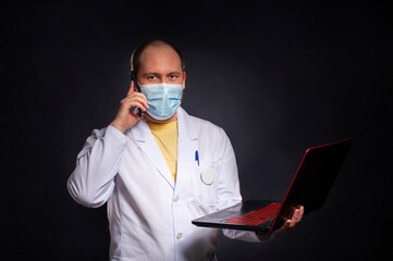 young man in a doctor's suit studies a medical history in a laptop - 495464938
