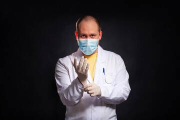 young man dressed as a laboratory assistant puts on disposable gloves - 495464940