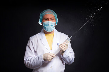 young man dressed as a laboratory assistant with an enema syringe - 495464941
