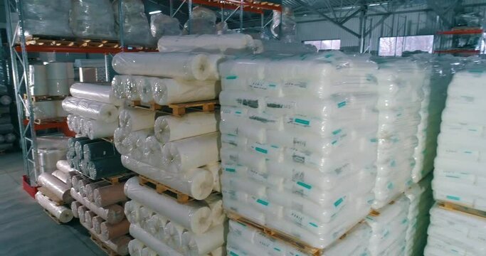 Spunbond in rolls in the warehouse of the factory. Warehouse of raw materials at the factory. Lots of raw material bag for production.