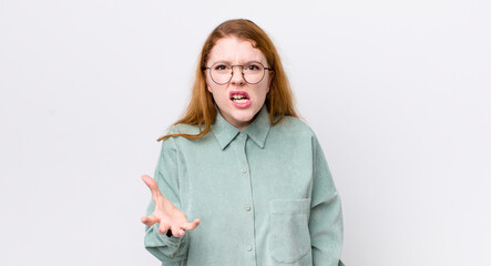 pretty red head woman looking angry, annoyed and frustrated screaming wtf or what’s wrong with you