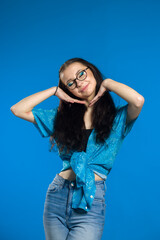 Lifestyle concept - Portrait of young stylish girl laughing, pretty girls wearing casual clothing smiling , isolated over blue background.