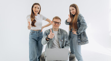 Two woman and man using laptop and smile on white background