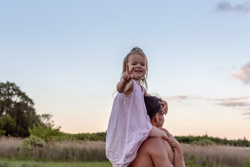 Father carrying his little daughter on shoulders with blue sky background. Happy loving family....