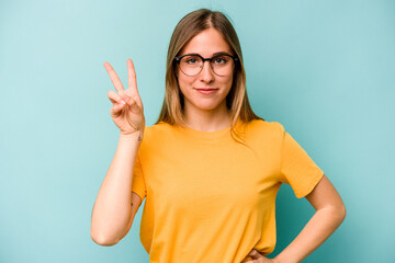 Fototapeta premium Young caucasian woman isolated on blue background joyful and carefree showing a peace symbol with fingers.