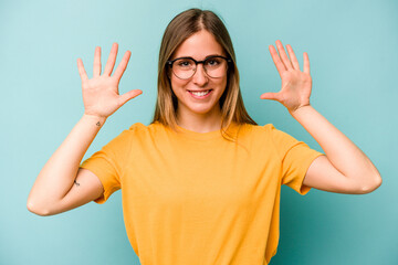 Young caucasian woman isolated on blue background showing number ten with hands.