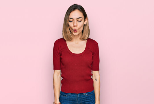 Young blonde girl wearing casual clothes making fish face with lips, crazy and comical gesture. funny expression.