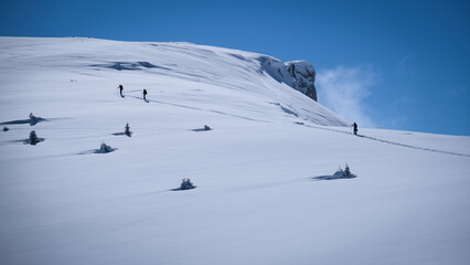 Ski touring skiers in Bucegi Mountains on a beautiful sunny day
