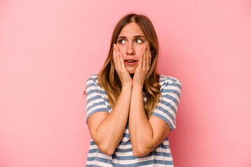 Young caucasian woman isolated on pink background scared and afraid.