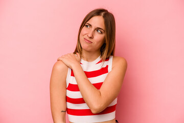 Young caucasian woman isolated on pink background having a shoulder pain.