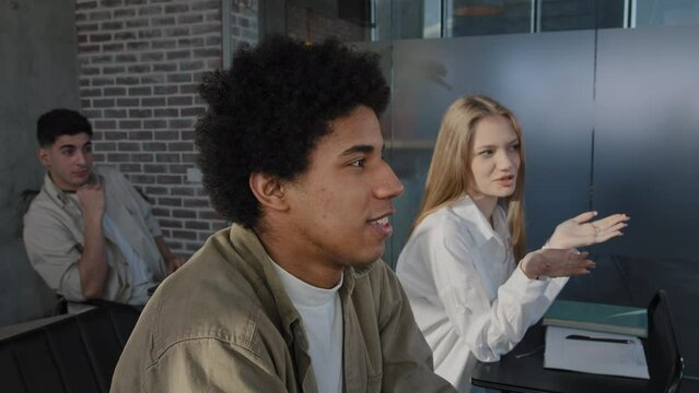 Young diverse group students sitting in classroom at lesson answering question discussing new topic with teacher communicate with lecturer studying at college study subject higher education concept