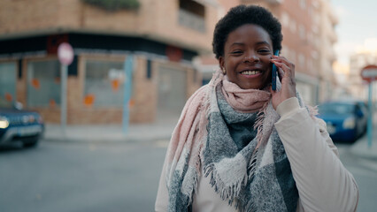 Young african american woman smiling confident talking on the smartphone at street