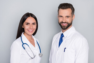 Profile photo of two friendly smart doctors toothy smile look camera isolated on grey color background